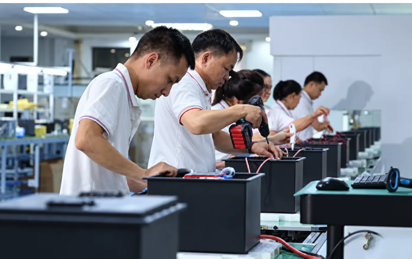 Technicians assembling industrial battery packs on a production line