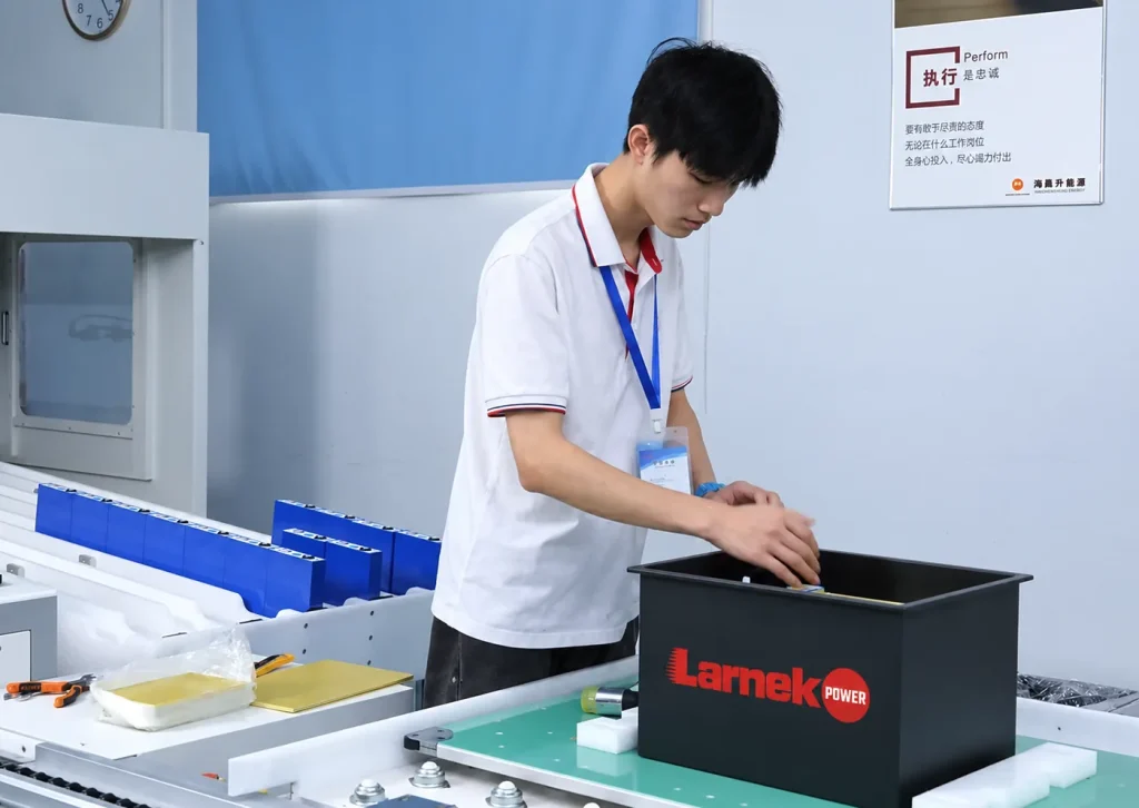 Assembler installing cells into a Larnek Power battery pack enclosure on the assembly line