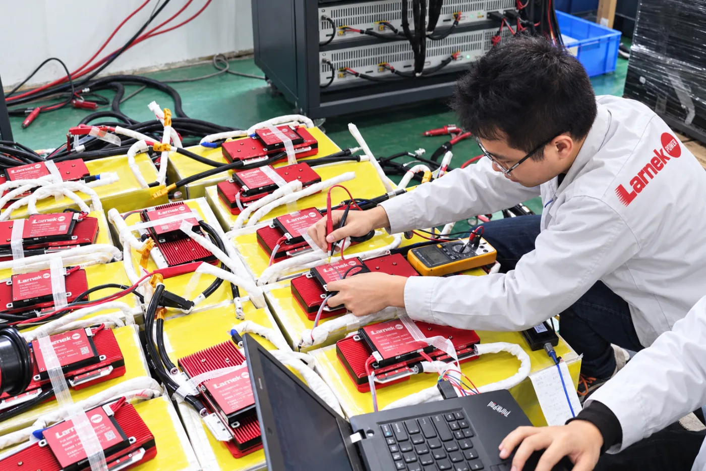 Engineer inspecting battery packs and connectors at a workstation