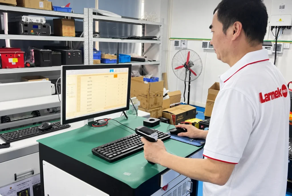 Technician scanning battery pack serial numbers at a production tracking station